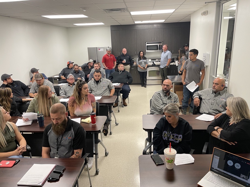 The image captures a group of professionals interacting in a well-furnished room during a convention. This setting highlights the importance of networking in the HVAC industry, showcasing how NexTech engages with potential clients and partners.